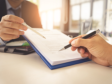Two people reviewing and discussing documents together.