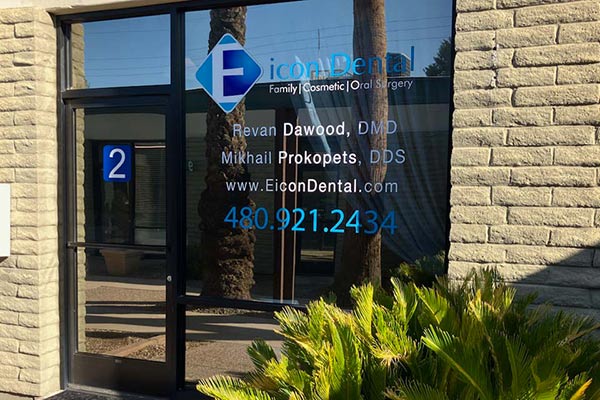 Dental office window with contact info and logo.