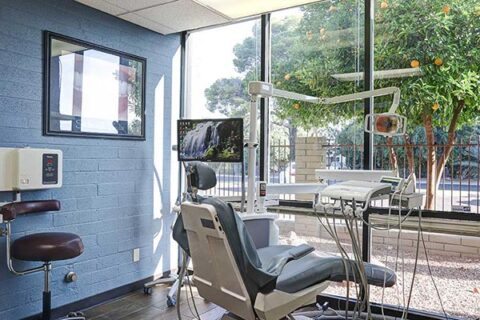 A bright dental office with a reclining chair and dental equipment.