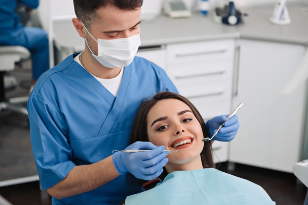 Dentist examining a smiling patient's teeth.